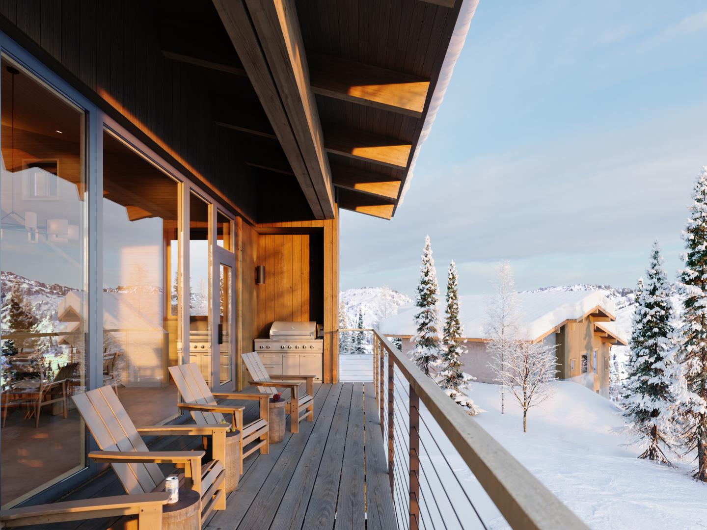 Wooden deck with chairs overlooking a snowy mountain landscape at sunrise.