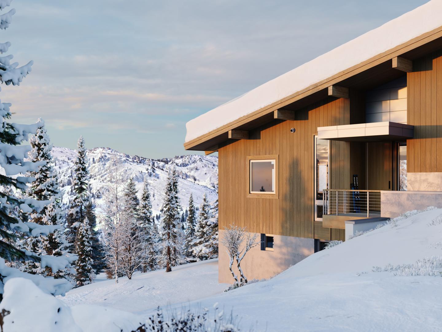 Snowy mountain cabin with trees under a blue sky.